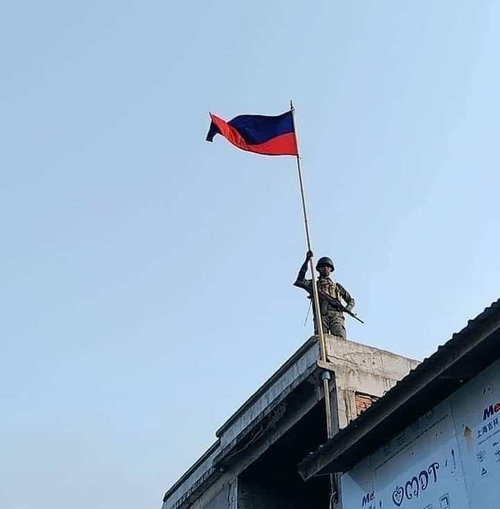 a soldier of the Arak Liberation Front, an FGA-aligned militia, raises the ALF's flag on a building in Laukham