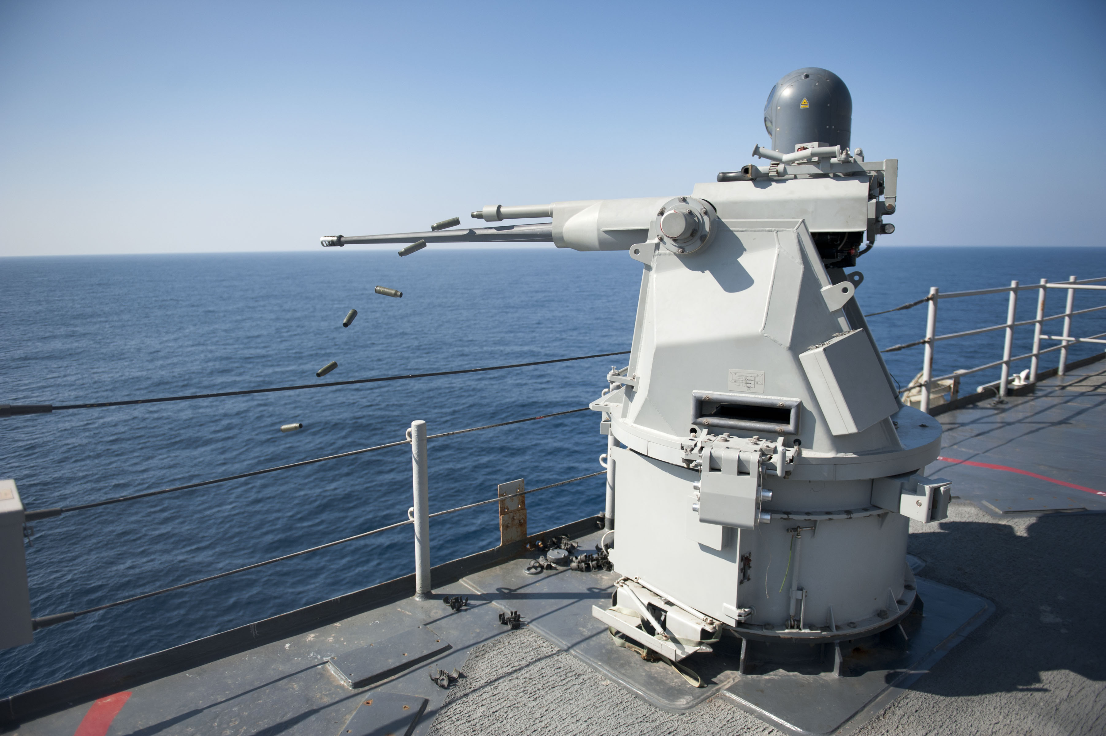US_Navy_111231-N-KS651-967_A_Mk_38_MOD_2_25mm_machine_gun_system_aboard_the_amphibious_dock_landing_ship_USS_Pearl_Harbor_%28LSD_52%29_ejects_casings_d.jpg