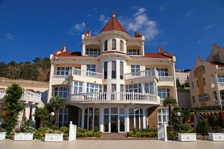 15246900-elegant-fasad-of-summer-resort-villa-with-classical-white-balconies-on-blue-sky-background.jpg